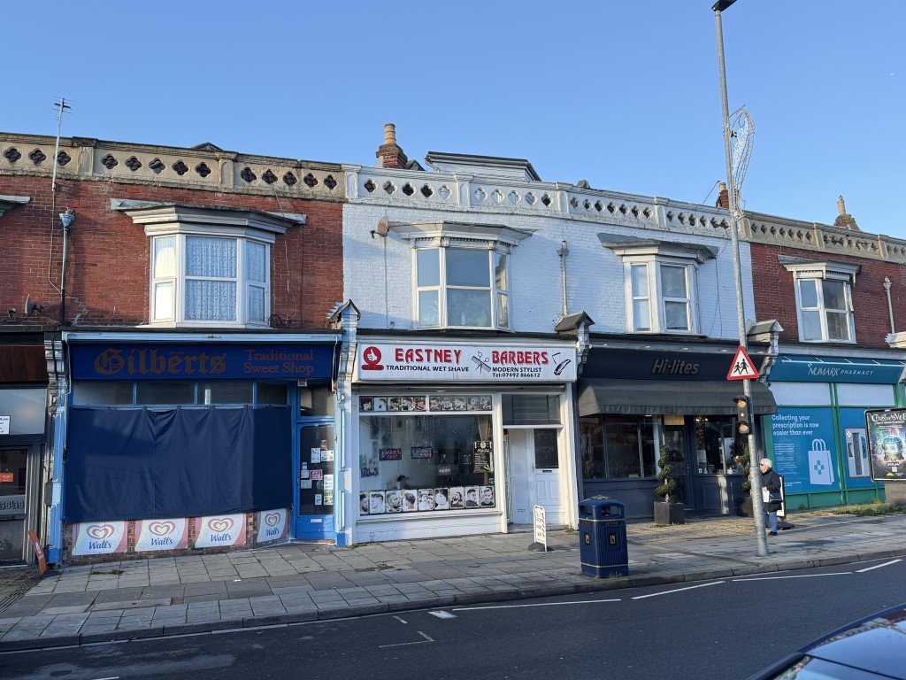 Lot: 167 - TWO-BEDROOM FIRST FLOOR MAISONETTE - Front view of maisonette above barbers on main road
